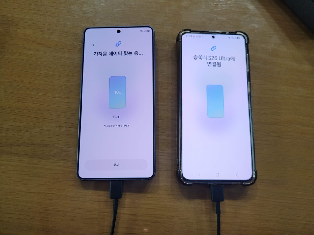 케이블 연결 두 스마트폰, 데이터 전송 진행 중. S26 Ultra 연결.