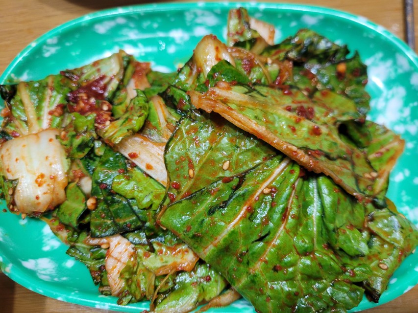 신선한 배추 겉절이, 매콤한 양념, 참깨 뿌려진 녹색 접시