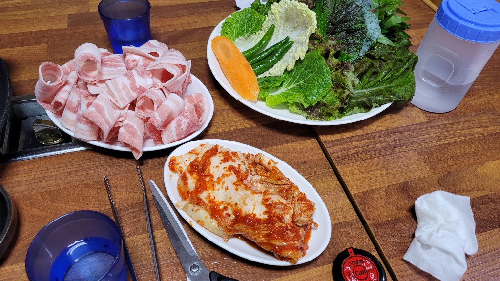 얇게 썬 삼겹살, 신선한 쌈채소, 김치 곁들인 한식 상차림