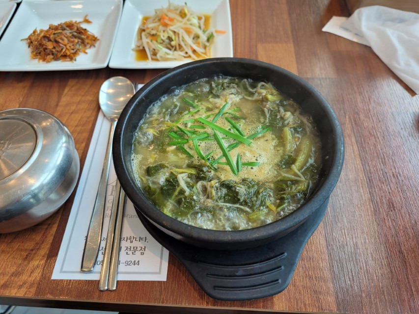 뜨거운 뚝배기 채소국, 쪽파 고명, 멸치 콩나물 반찬.