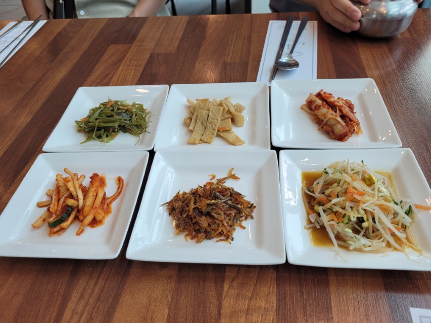 여섯 가지 한국 반찬, 나무 식탁 위 정갈한 한식 차림.