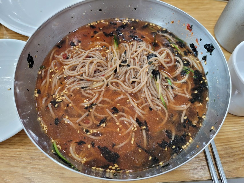 금속 그릇 시원한 붉은 육수 메밀 막국수, 김가루 깨 고명