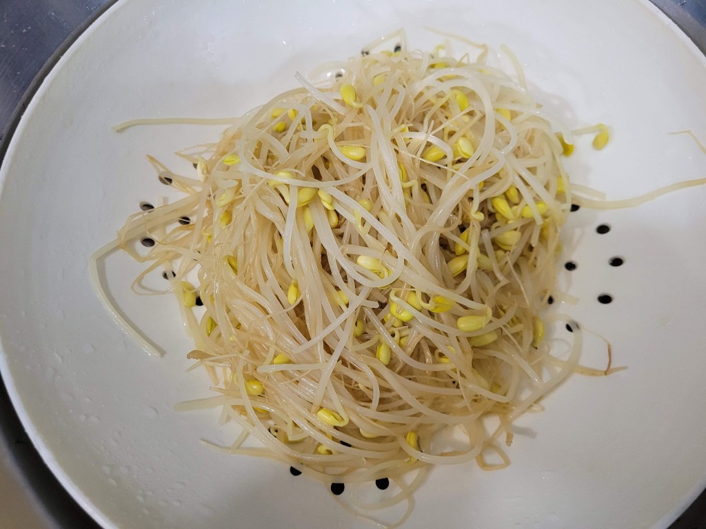 흰 채반에 담겨있는 신선한 연노랑 콩나물 요리 재료