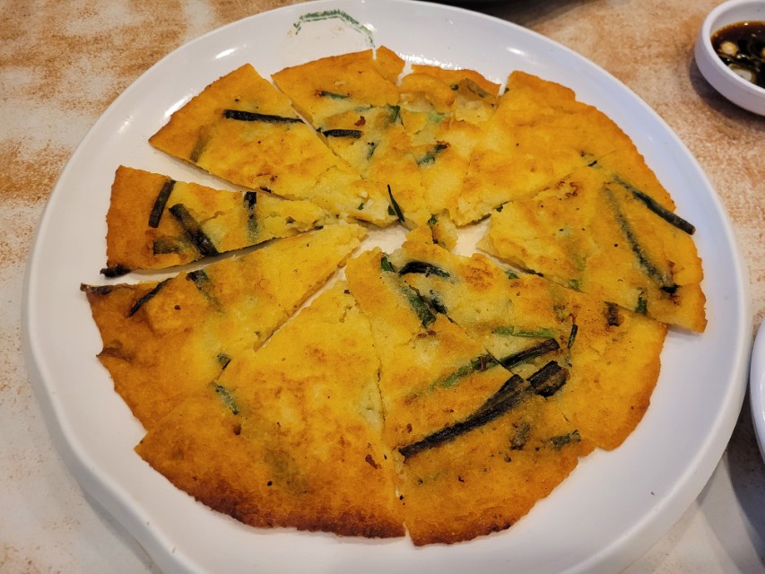 황금빛 노란 빈대떡, 파 송송, 조각내어 흰 접시에.