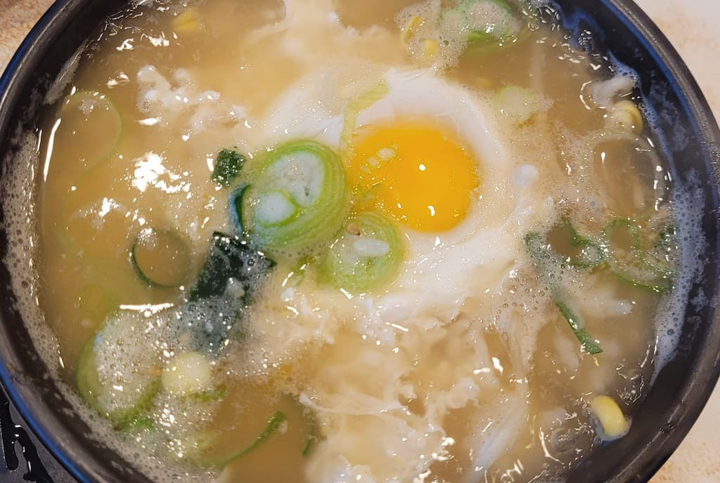 뜨거운 뚝배기 콩나물국, 날계란 노른자, 파, 콩나물