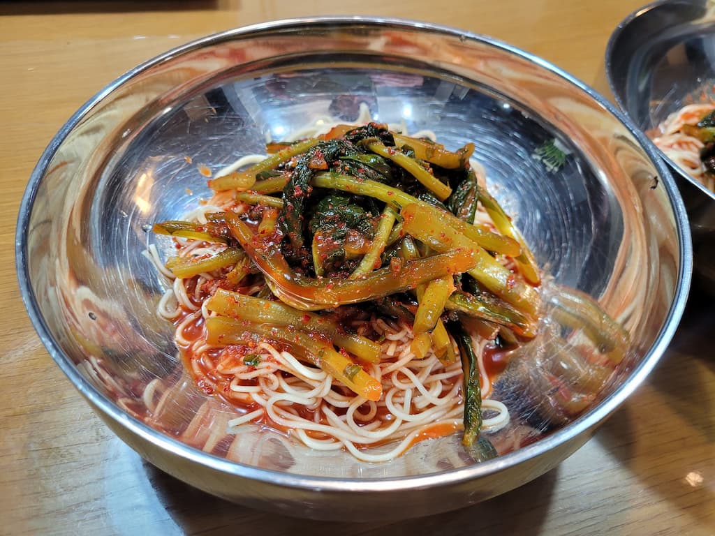 스테인리스 그릇에 담긴 매콤한 열무 비빔국수 면 요리