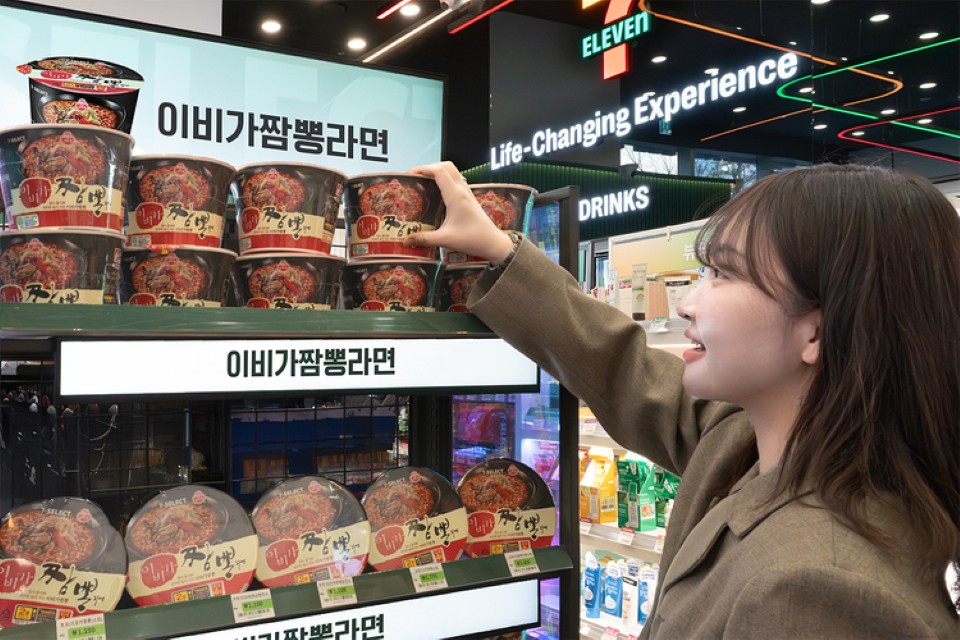 7-ELEVEN 진열된 이비가짬뽕라면 컵라면. 제품 선택하는 손.