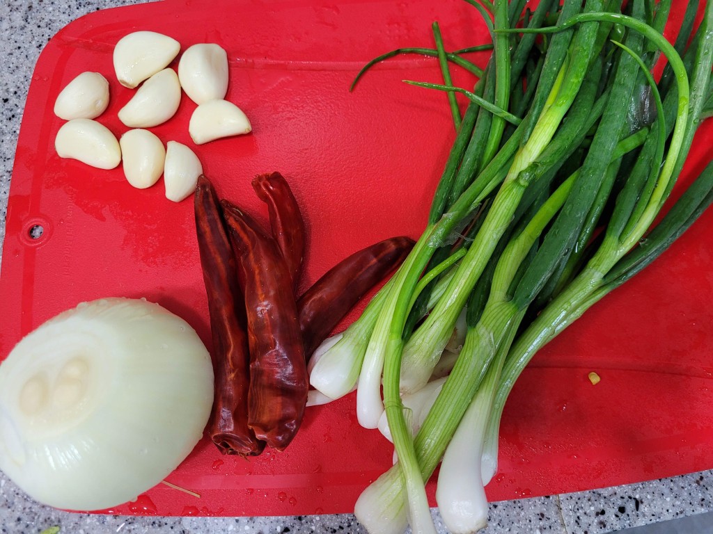 빨간 도마 위 마늘, 건고추, 양파, 대파 신선한 요리 재료