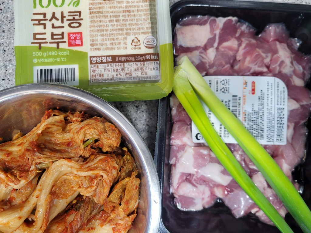 두부, 김치, 돼지고기, 파 함께 준비된 요리 재료