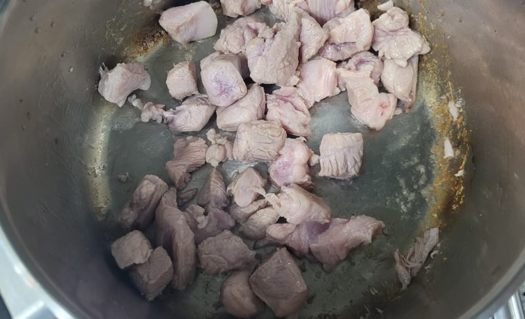 금속 냄비 속 옅은 고기 덩어리, 냄비 벽면 노릇하게 익어감