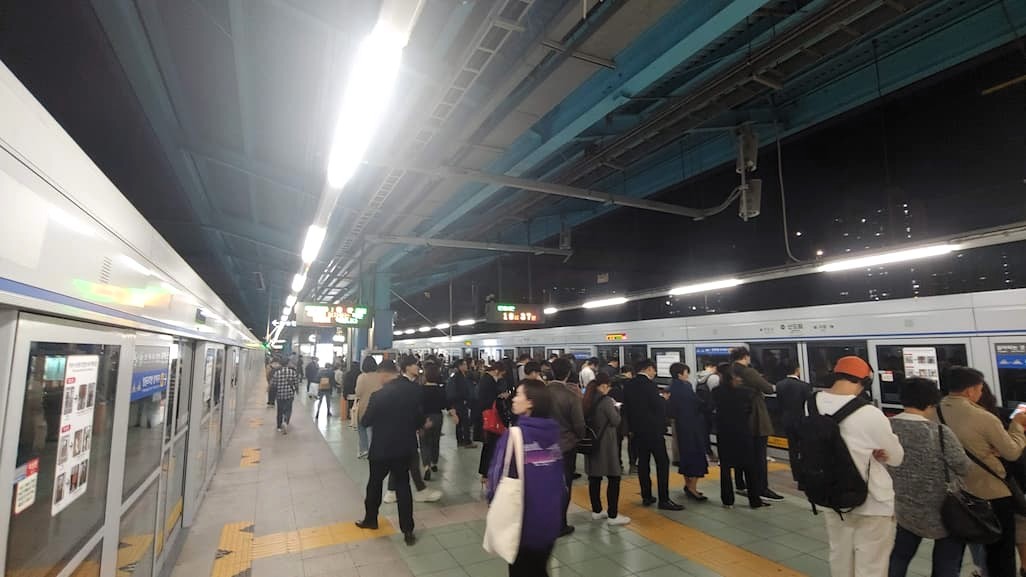 야간 지하철 승강장, 두 대 열차 사이 혼잡한 대기 공간