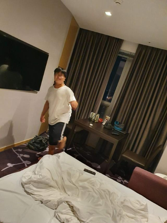 호텔 객실, 흰 티셔츠 착용자 이동, TV와 어질러진 침대