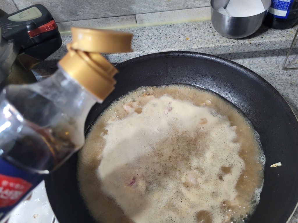 간장 병, 검은 팬 끓는 국물 요리에 간장 붓는 중