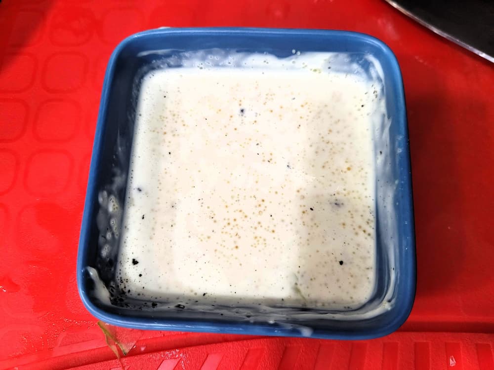 빨간 도마 위 파란 용기 속 하얀 거품 반죽