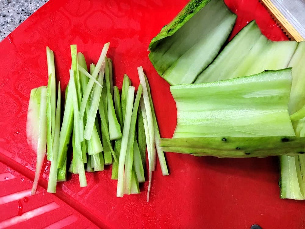 빨간 도마 위, 채 썬 오이와 넓게 손질된 오이