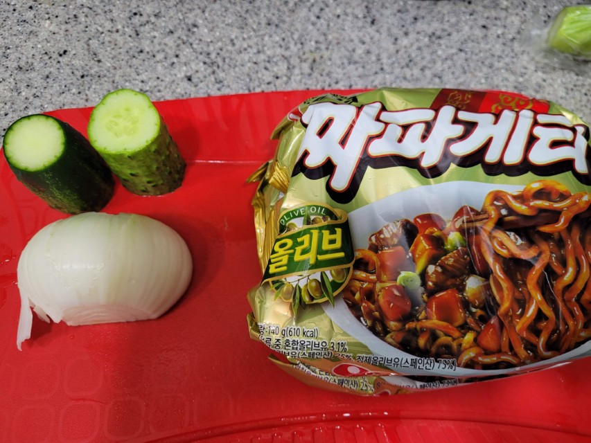 짜파게티 라면, 오이, 양파, 빨간 도마 위 재료.