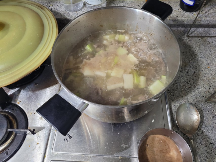 가스레인지 위 끓는 고기 깍둑썰기 채소 황태해장국