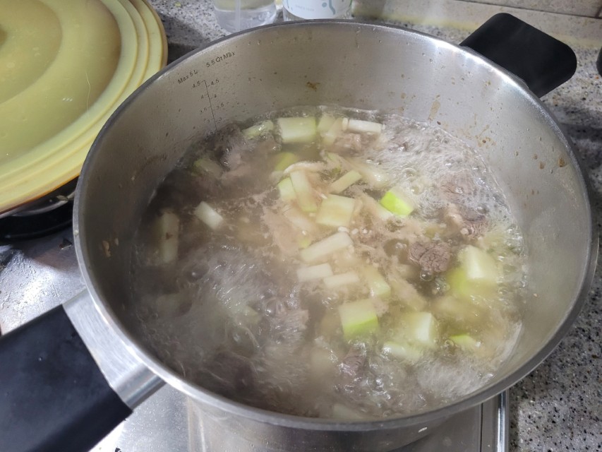 끓는 소고기 무국 냄비, 무 조각과 소고기 건더기