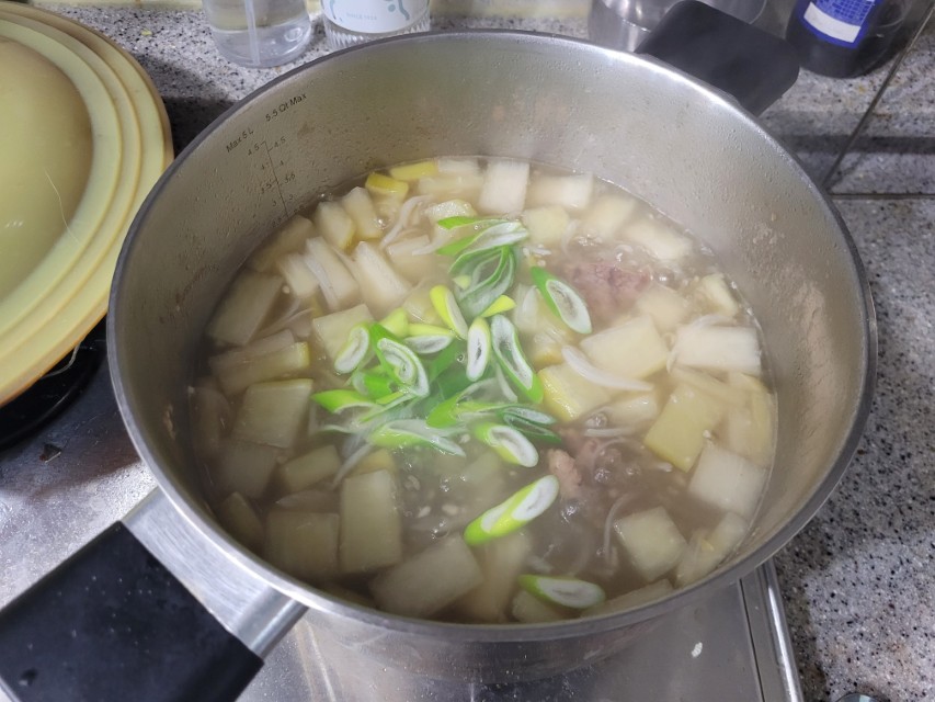 끓는 냄비 속 무, 대파, 고기 넣은 뜨거운 쇠고기 무국 요리