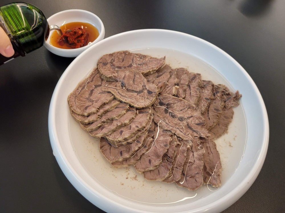 얇게 썬 소고기 수육 맑은 육수 매콤한 양념 간장 첨가