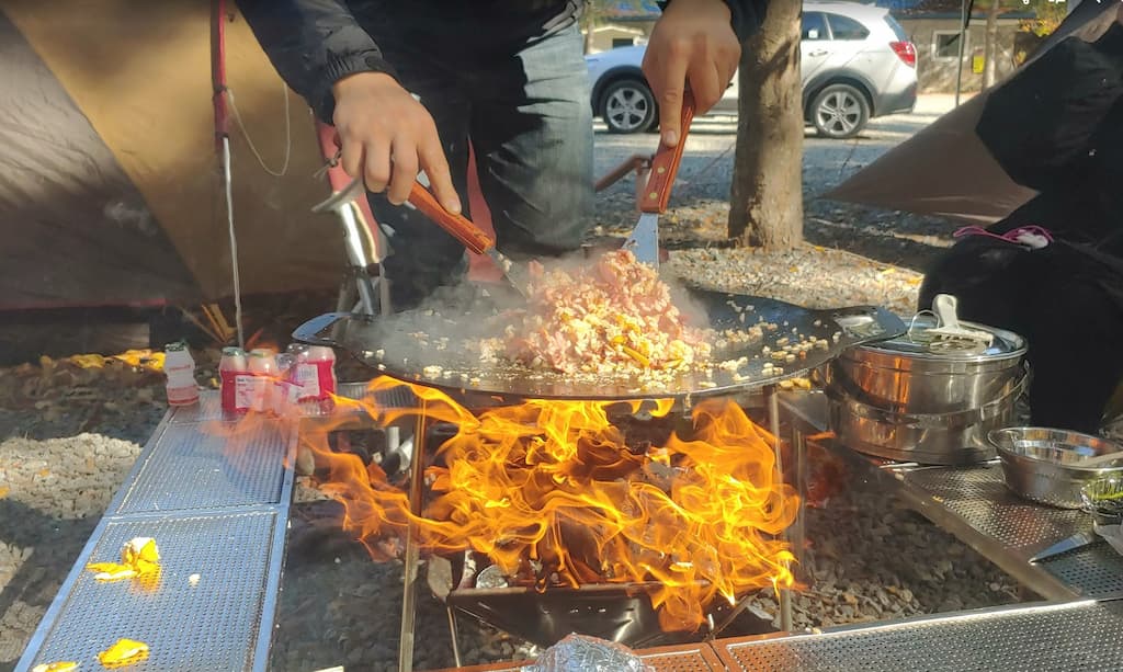 캠핑 야외 주걱 이용 팬에 볶음 요리, 뜨거운 불꽃
