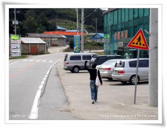 도로 걷는 주체, 팔 들어 올림, 주차 차량과 횡단보도 표지판