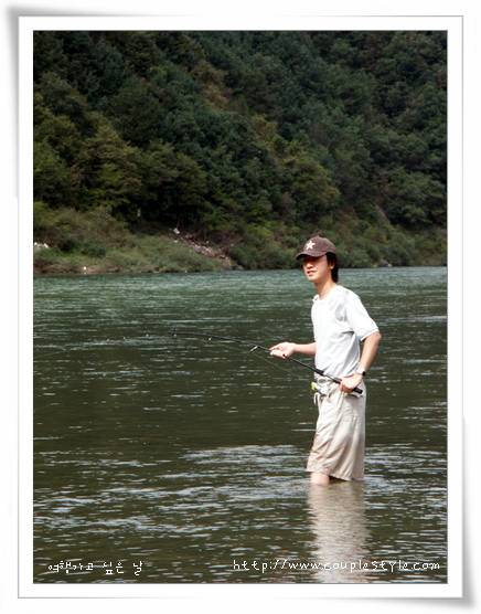 강물 속 모자 쓰고 낚시, 푸른 산림 배경