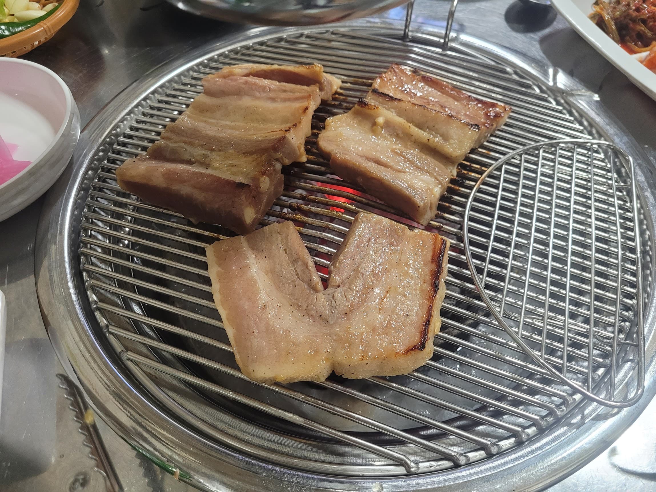 뜨거운 숯불 석쇠에 구워지는 두툼한 삼겹살, 한국식 바비큐