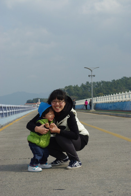 교량 위, 밝게 웃는 성인 유아가 아이스크림 콘 함께 들고 포옹