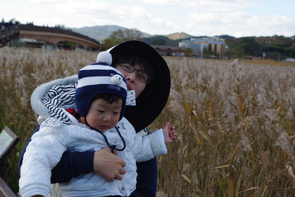 따뜻한 옷차림 보호자 아기 갈대밭에서 함께 겨울 나들이