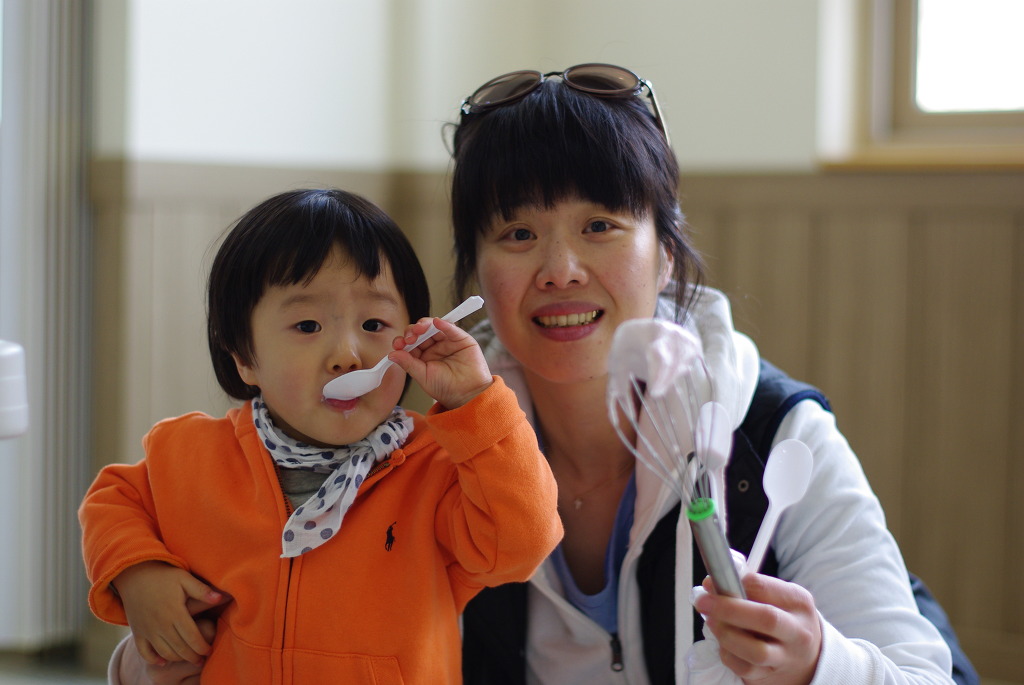 환히 웃는 아이 숟가락 시식, 어른 거품기와 숟가락 든.