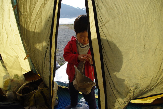 캠핑 텐트 입구, 빨간 옷 아이 버킷 햇 손에 쥐고 있음