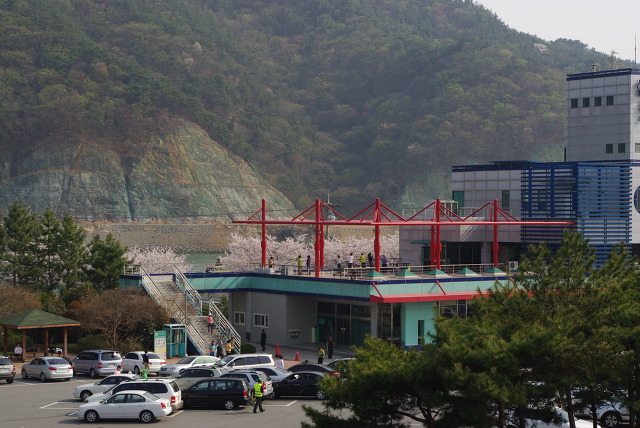 빨간 구조물 테라스, 벚꽃, 주차장, 산 배경 현대 건물